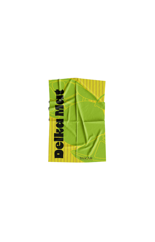 Green towel with leaf design and 'Delikat' text on a yellow background